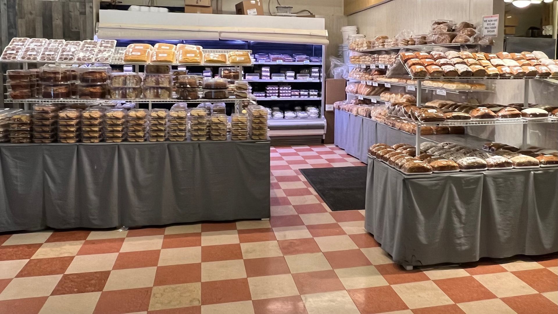 A bakery with a checkered floor and lots of bread on display