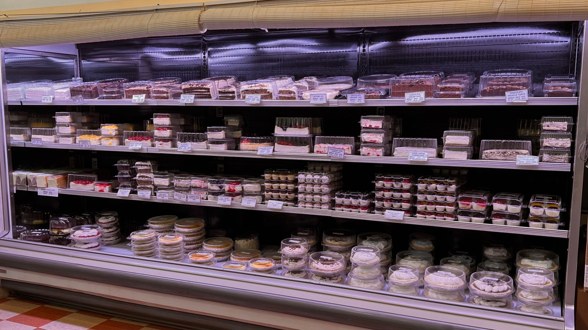 A refrigerator filled with lots of food in a grocery store.