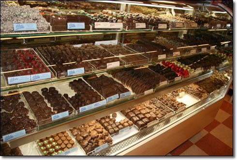 A display case filled with many different types of chocolates
