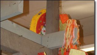 A clown is hanging from the ceiling of a building