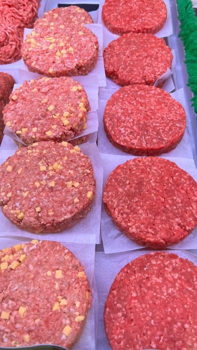 A bunch of hamburger patties are sitting on a table.