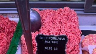 A pile of ground beef with a sign that says `` beef pork veal mixture ''.