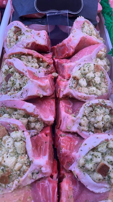 A close up of a tray of stuffed pork chops on a table.