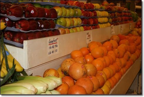 A display of fruits and vegetables including apples and oranges