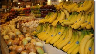 A bunch of bananas are sitting on a table with other fruits