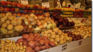 A variety of fruits and vegetables are on display in a grocery store.