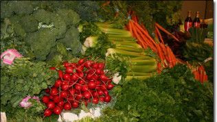 A bunch of vegetables including broccoli , carrots , celery and radishes