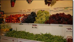 A display of fruits and vegetables including grapes and green beans