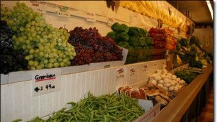 A variety of fruits and vegetables are on display in a grocery store.