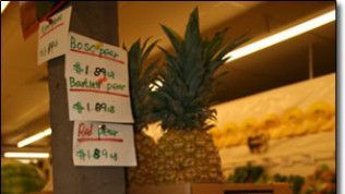 A pineapple is for sale in a grocery store