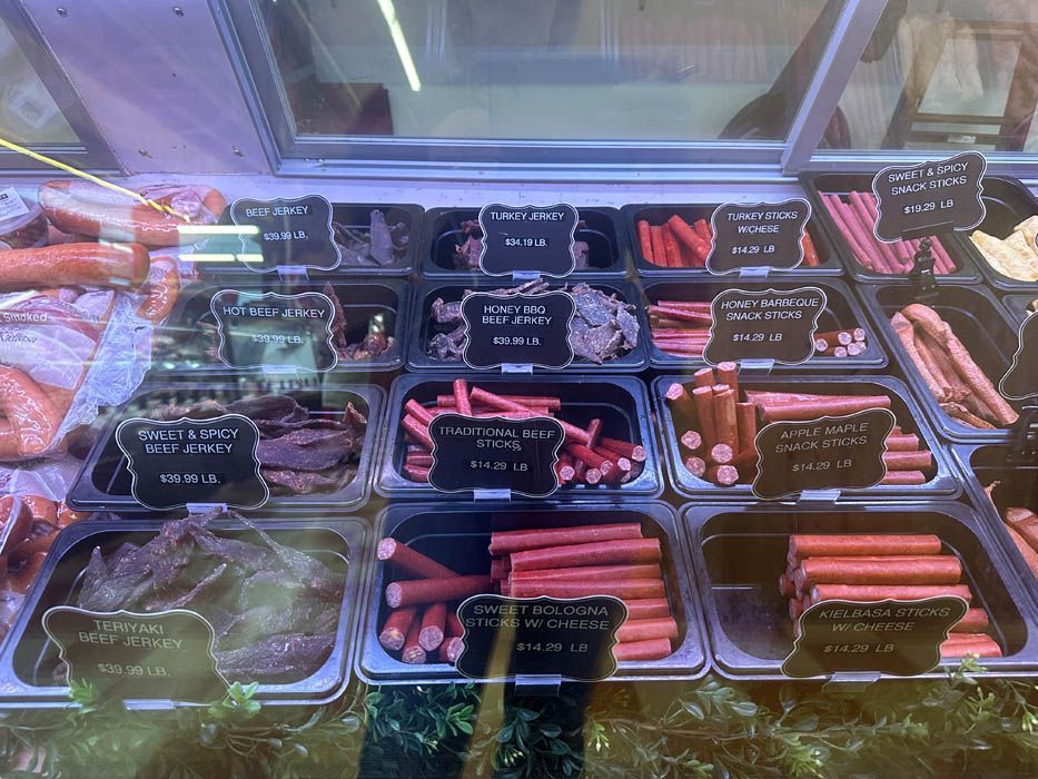 A display case filled with a variety of meats and sausages.