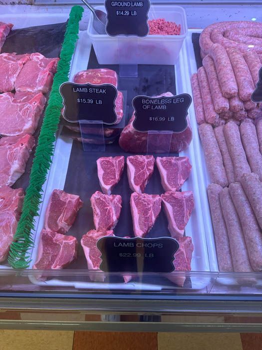 A display case filled with meat and sausages in a butcher shop.