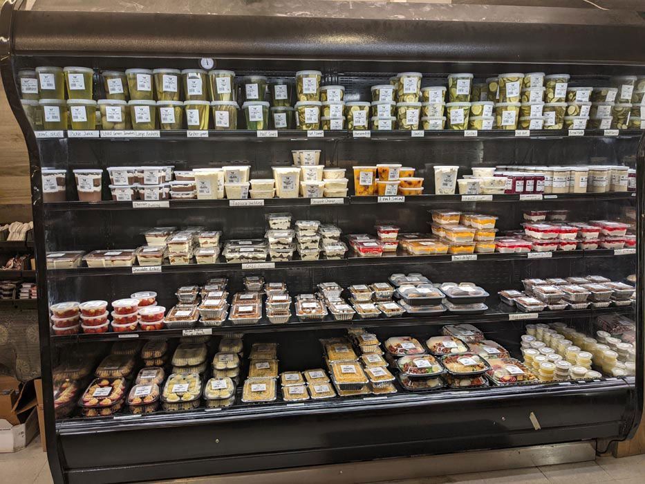 A grocery store refrigerator filled with lots of food