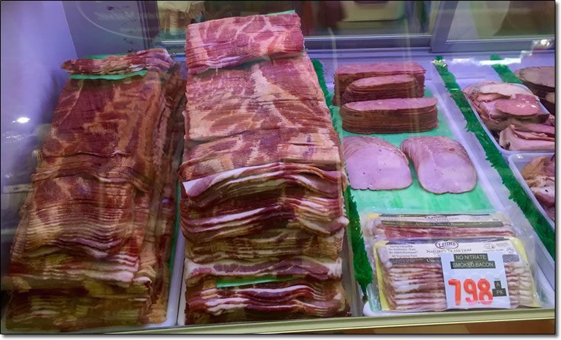 A display case filled with meat and a price tag that says 198