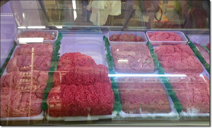 A display case filled with lots of different types of meat.