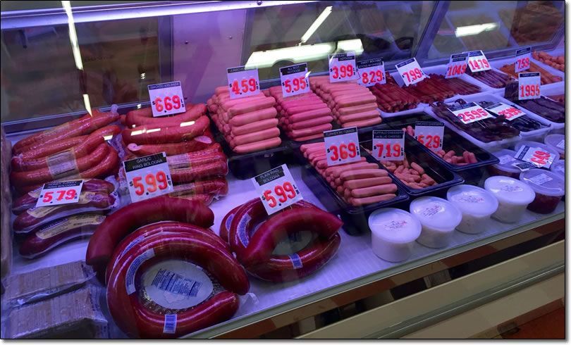 A display case filled with a variety of meats and sausages