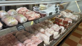 A display case filled with a variety of meats in a butcher shop.