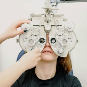 Person undergoing an eye exam with a phoropter in a clinic