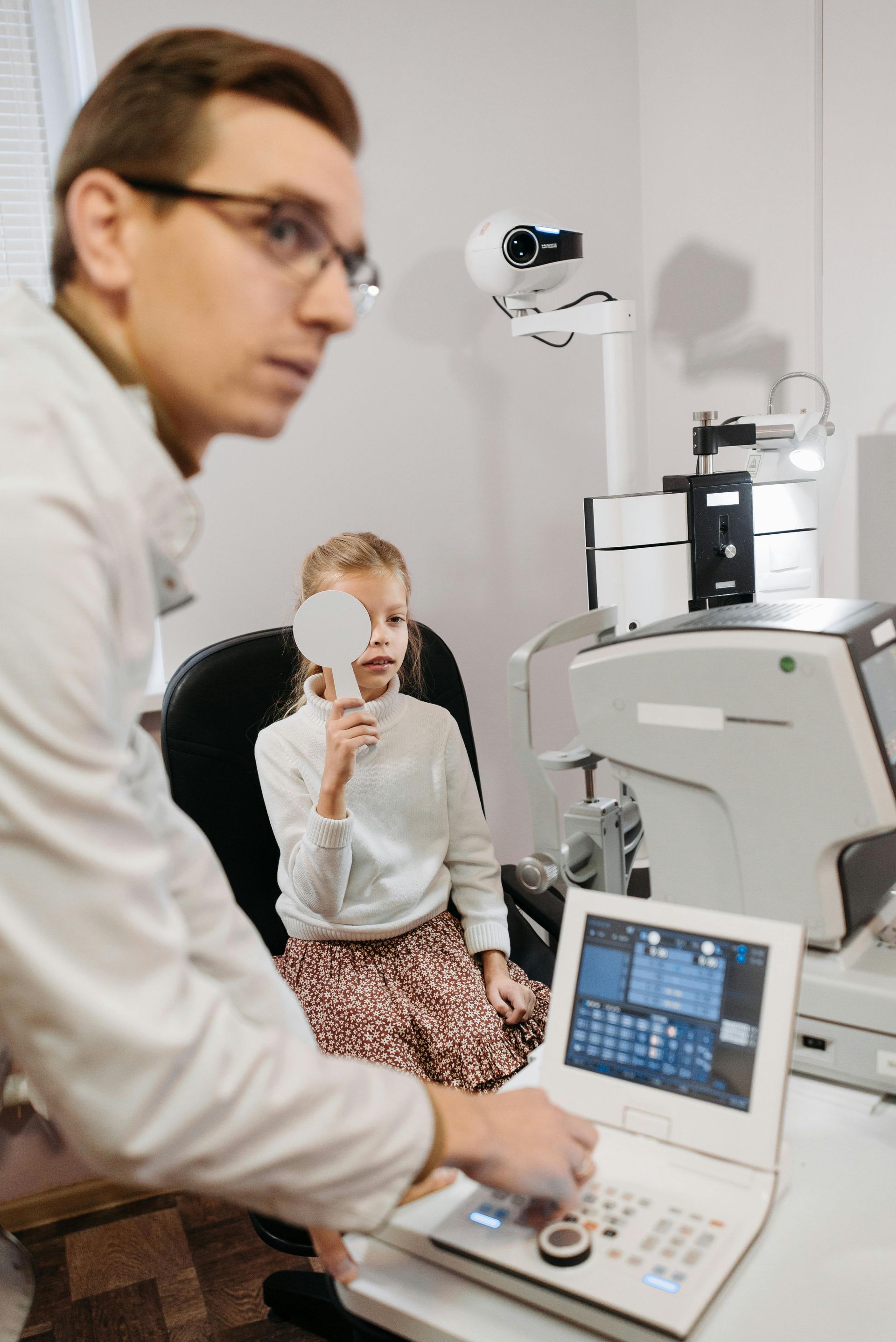 Eye exam with doctor and patient at a slit lamp in a bright clinic