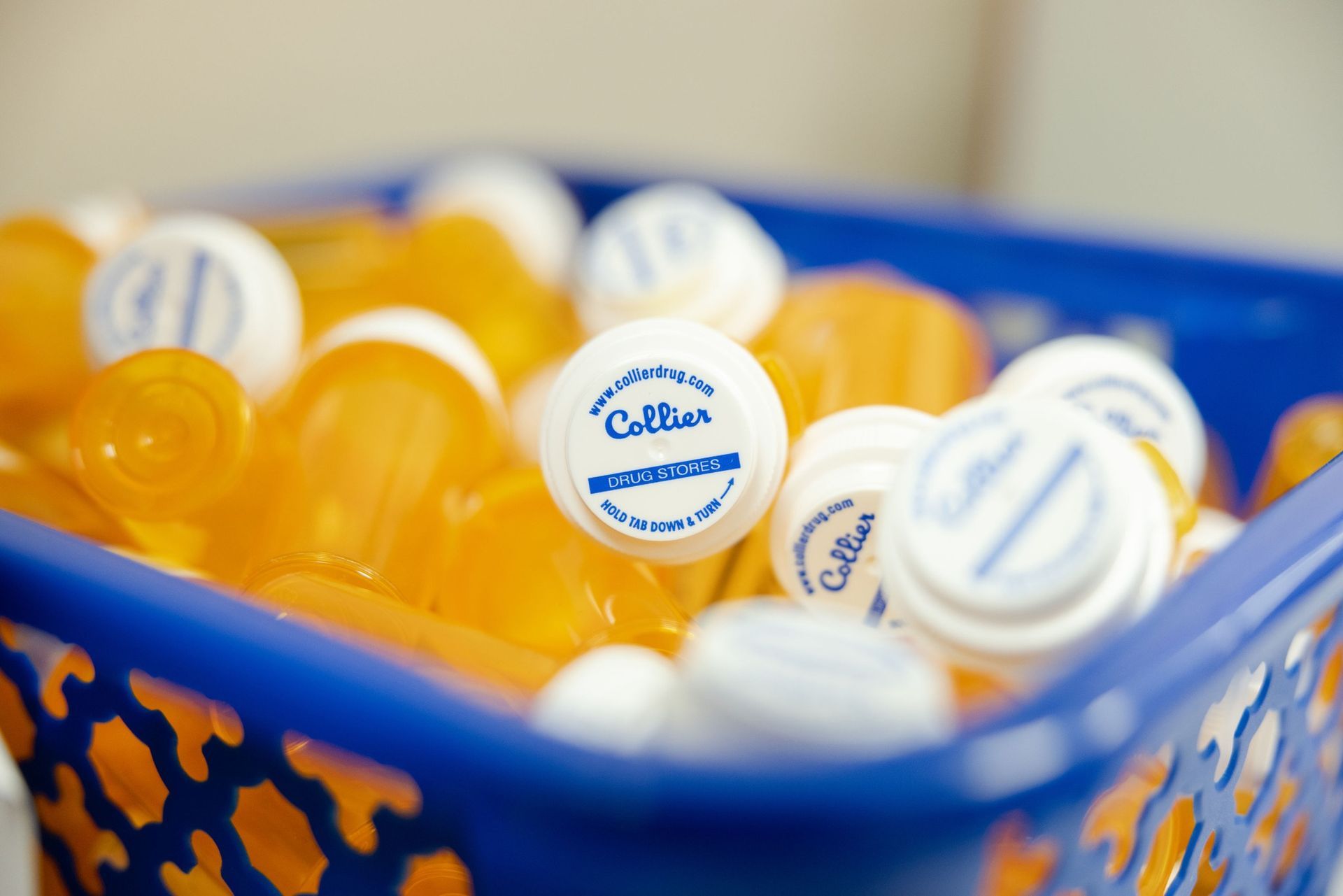 A blue basket filled with bottle caps that say collier