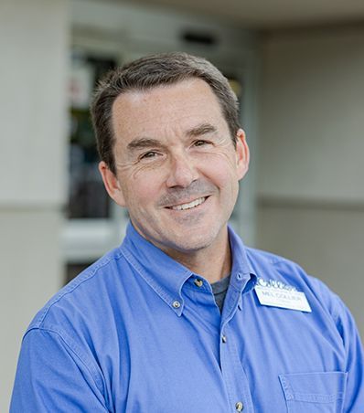 A man in a blue shirt is smiling for the camera.