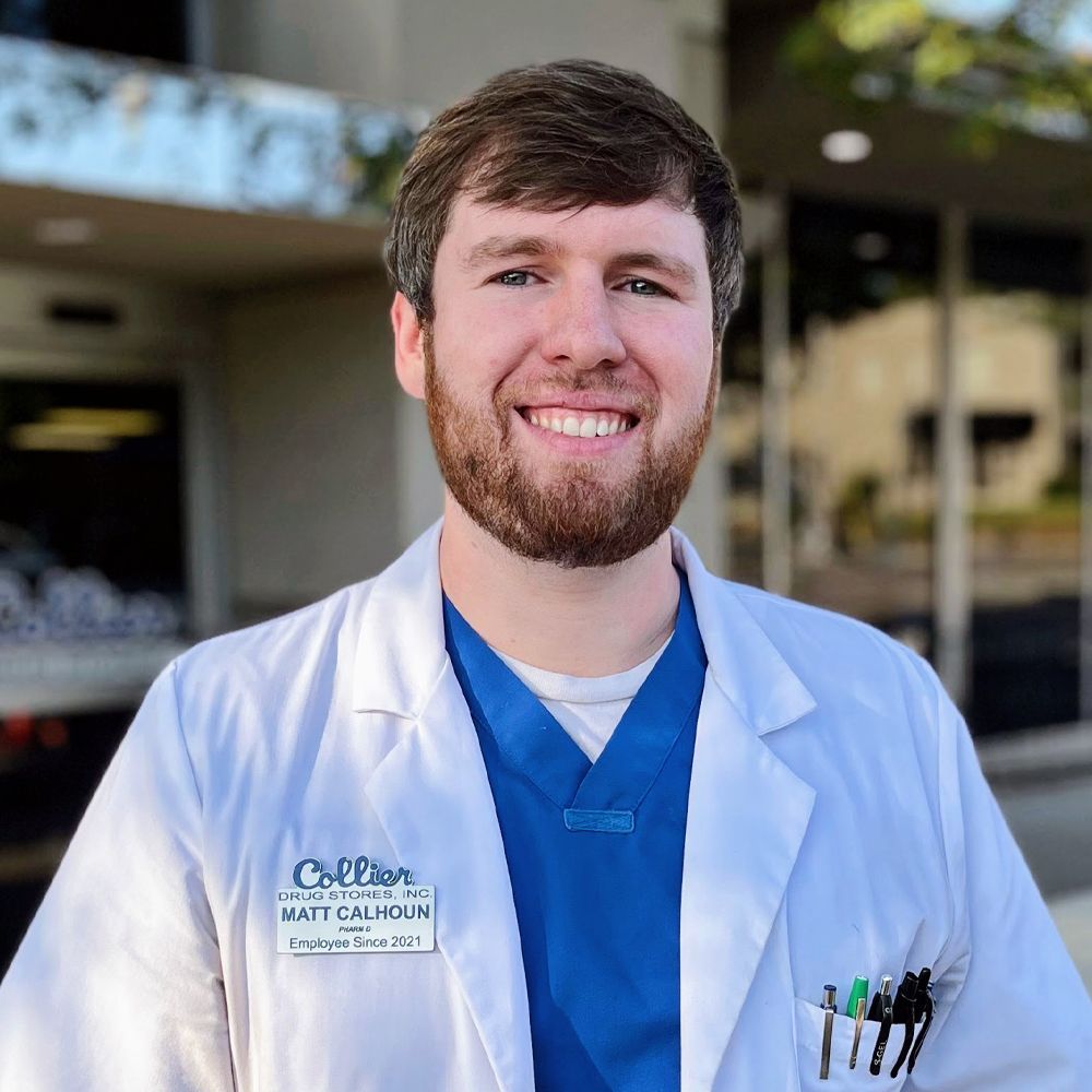 A man in a white coat is smiling for the camera.