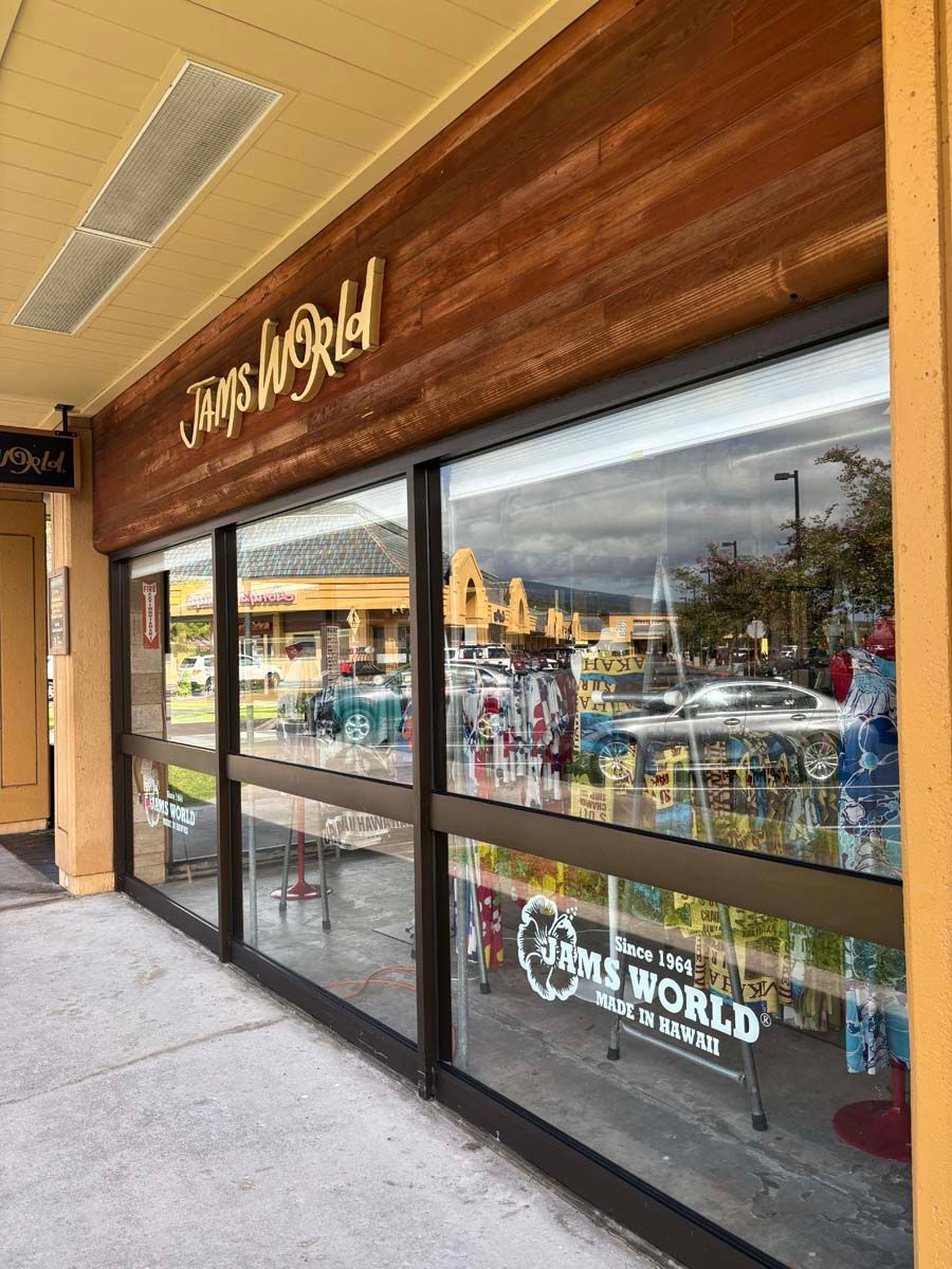 A store front with lots of windows and a wooden sign.