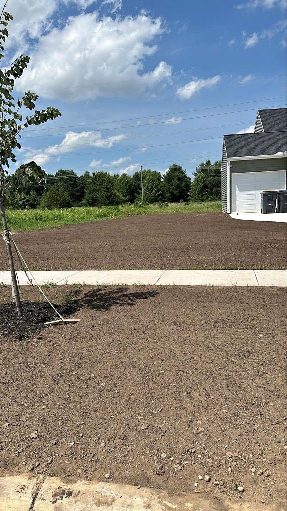 New house exterior with mulched yard, sidewalk, and cloudy blue sky