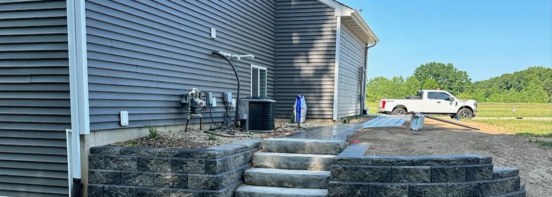 A white truck is parked in front of a house with stairs leading up to it.