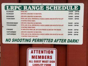 A schedule sign for the LRPC range, listing weekly hours and activities, with a smaller notice requiring guest sign-ins.