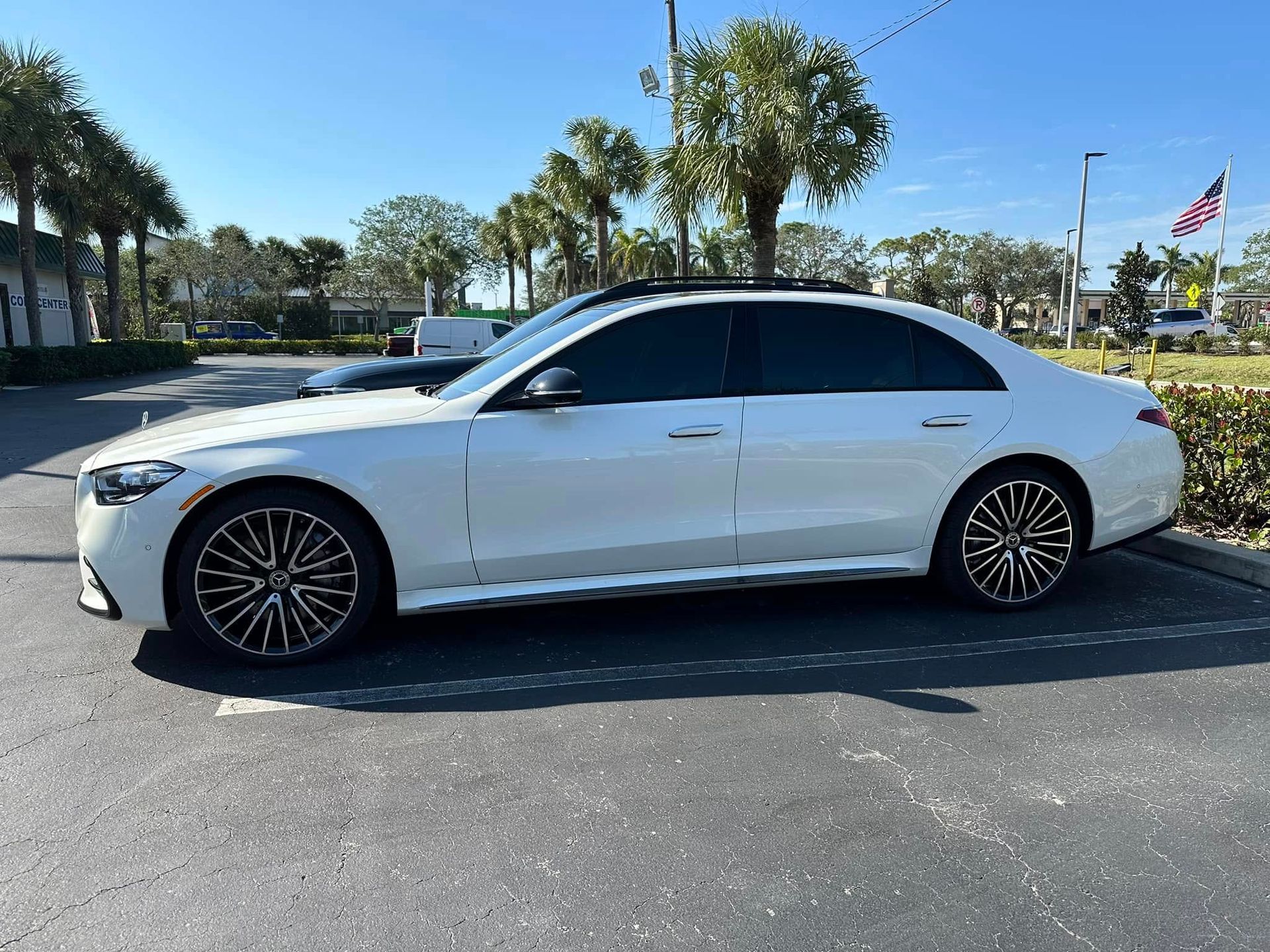 White Mercedes-Benz sedan with dark side windows, shown in profile.