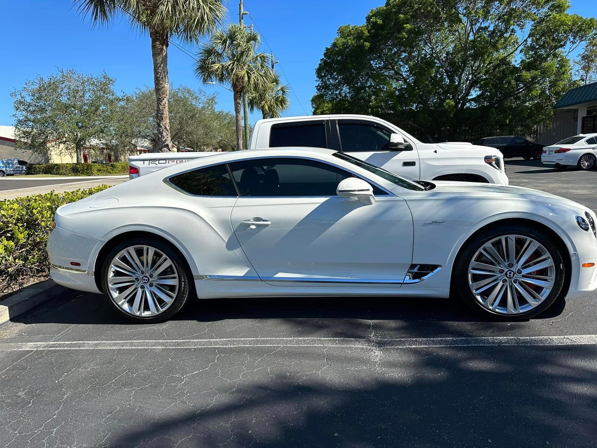 White Bentley coupe with dark side windows, shown in profile.