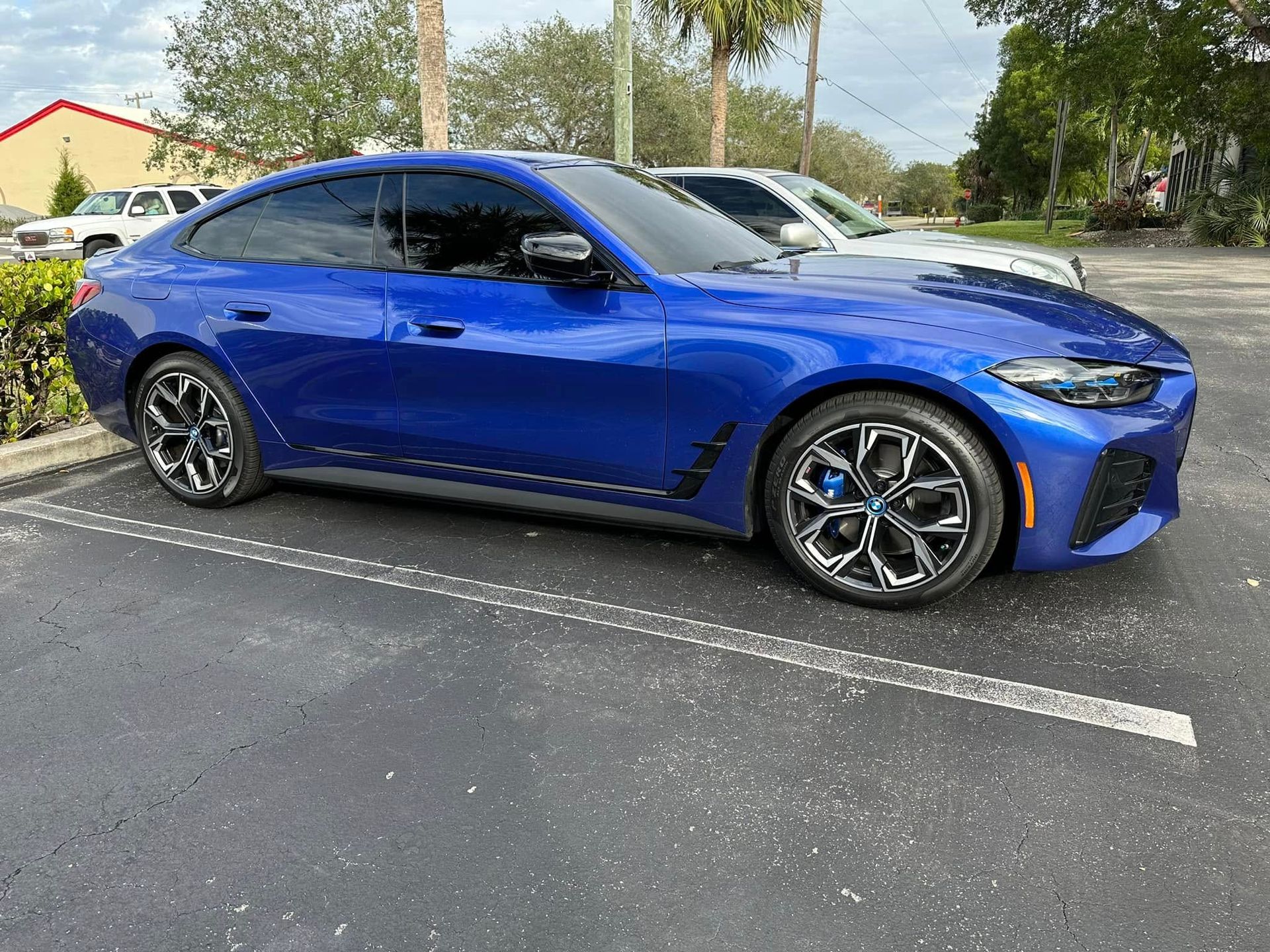 Blue BMW sedan with dark side windows, viewed from the front and side.