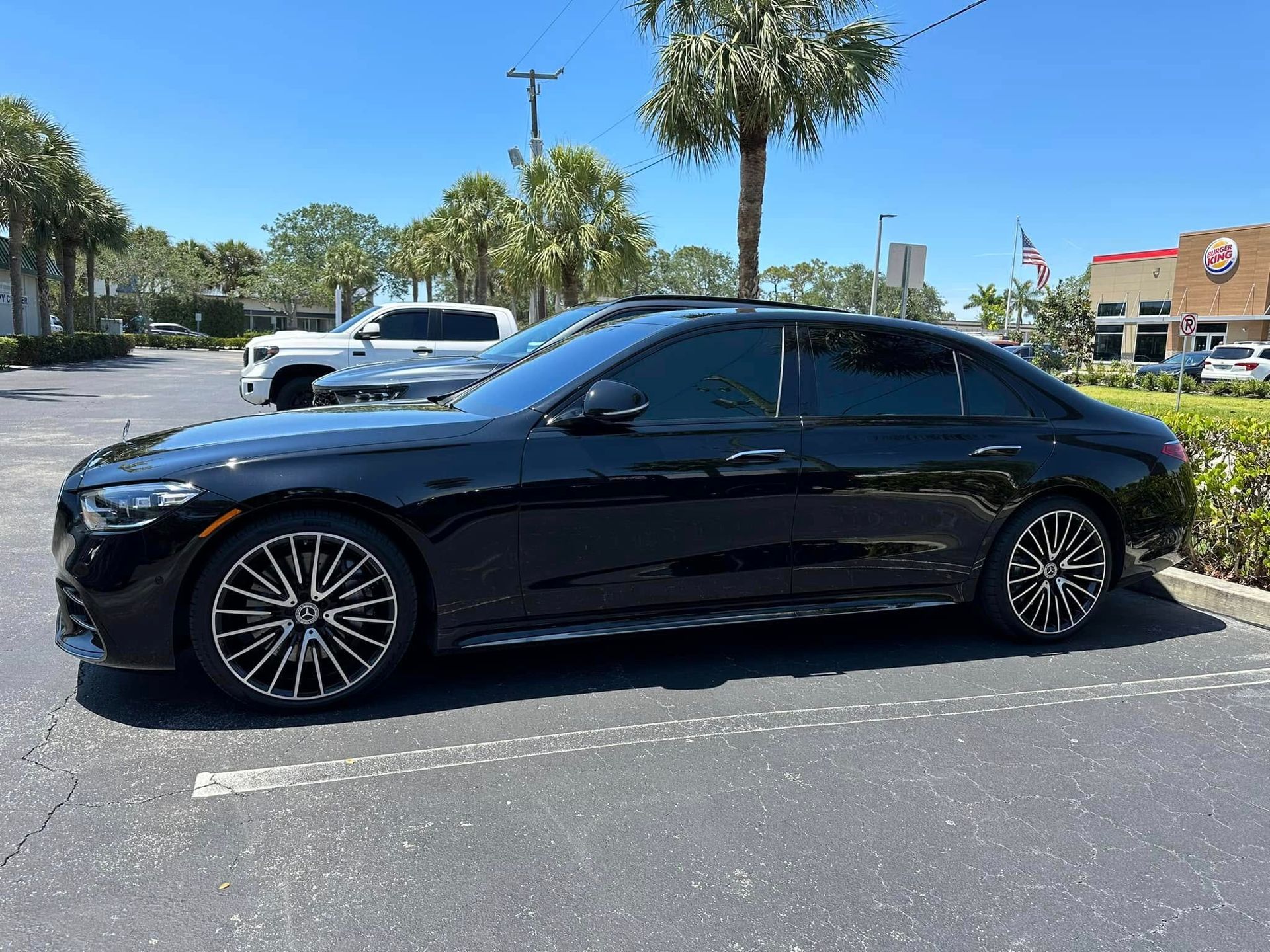 Dark blue Mercedes-Benz sedan with dark side windows, viewed from the front and side.