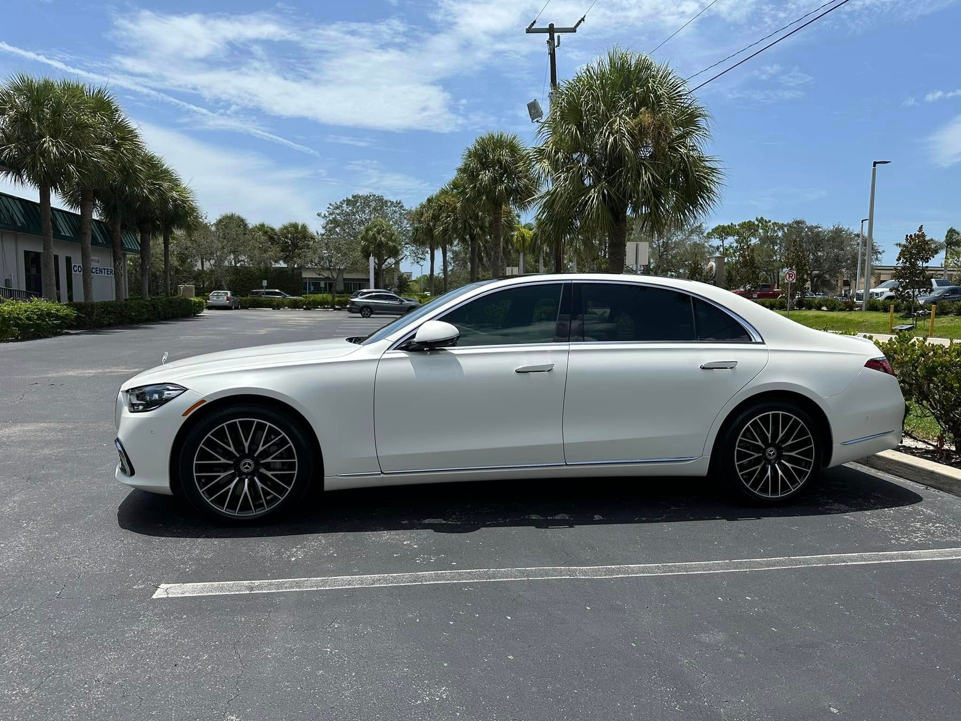 White Mercedes-Benz sedan with dark side windows, shown in profile.