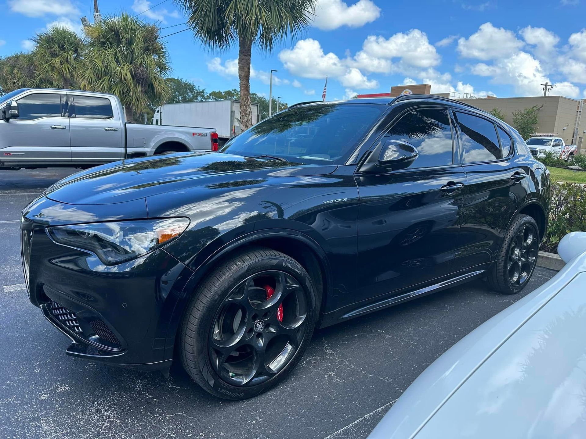 Dark blue Alfa Romeo SUV with dark windows and black wheels, viewed from the front and side.