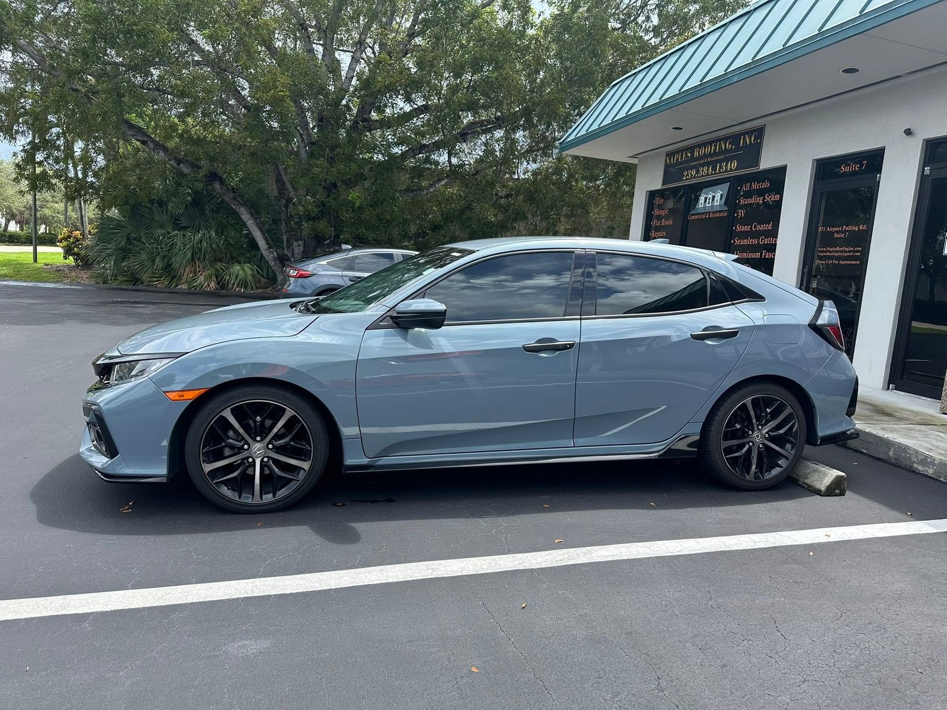 Light blue Honda hatchback with dark side windows, shown in profile.