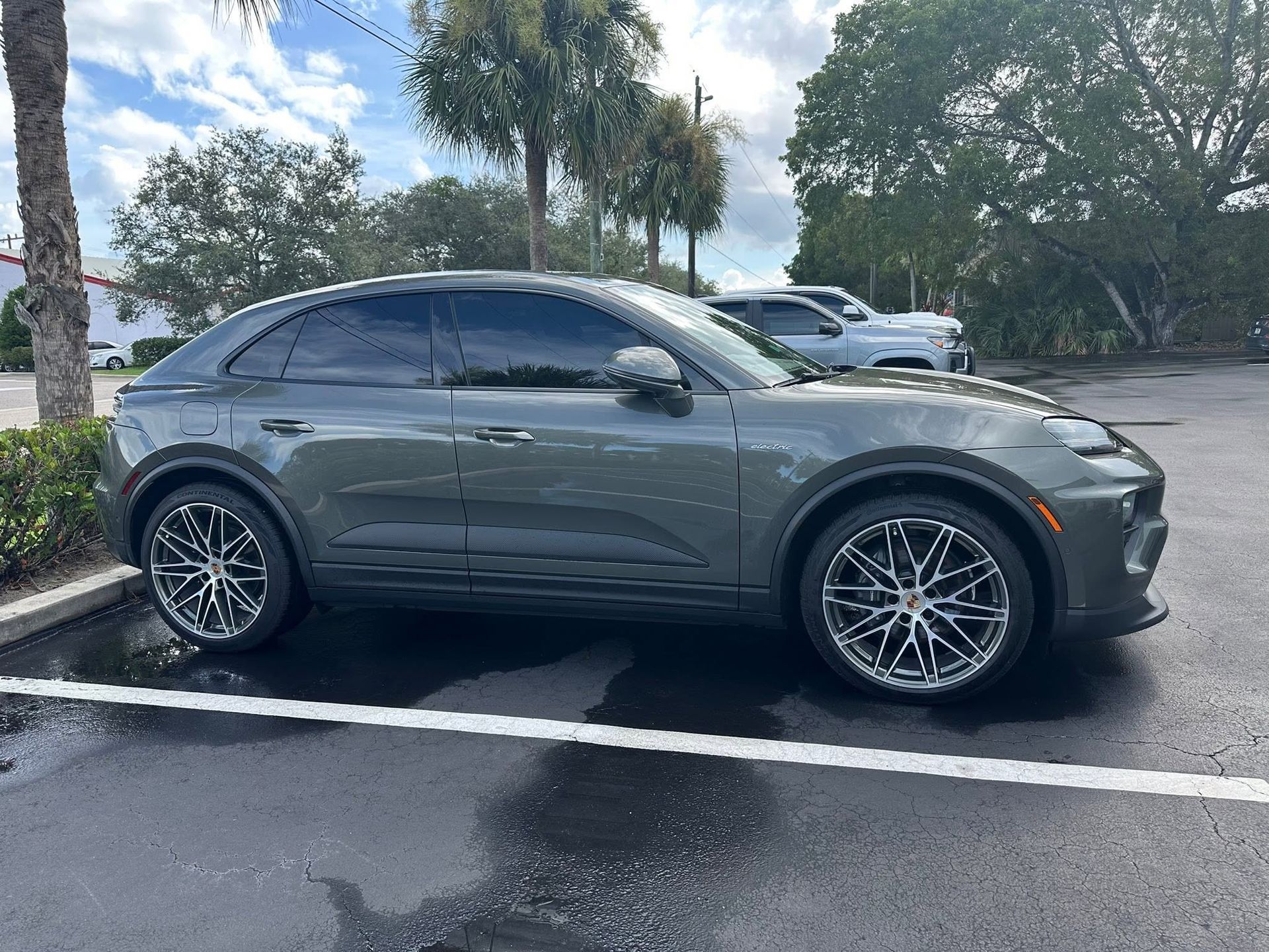 Gray Porsche SUV with dark side windows, viewed from the front and side.