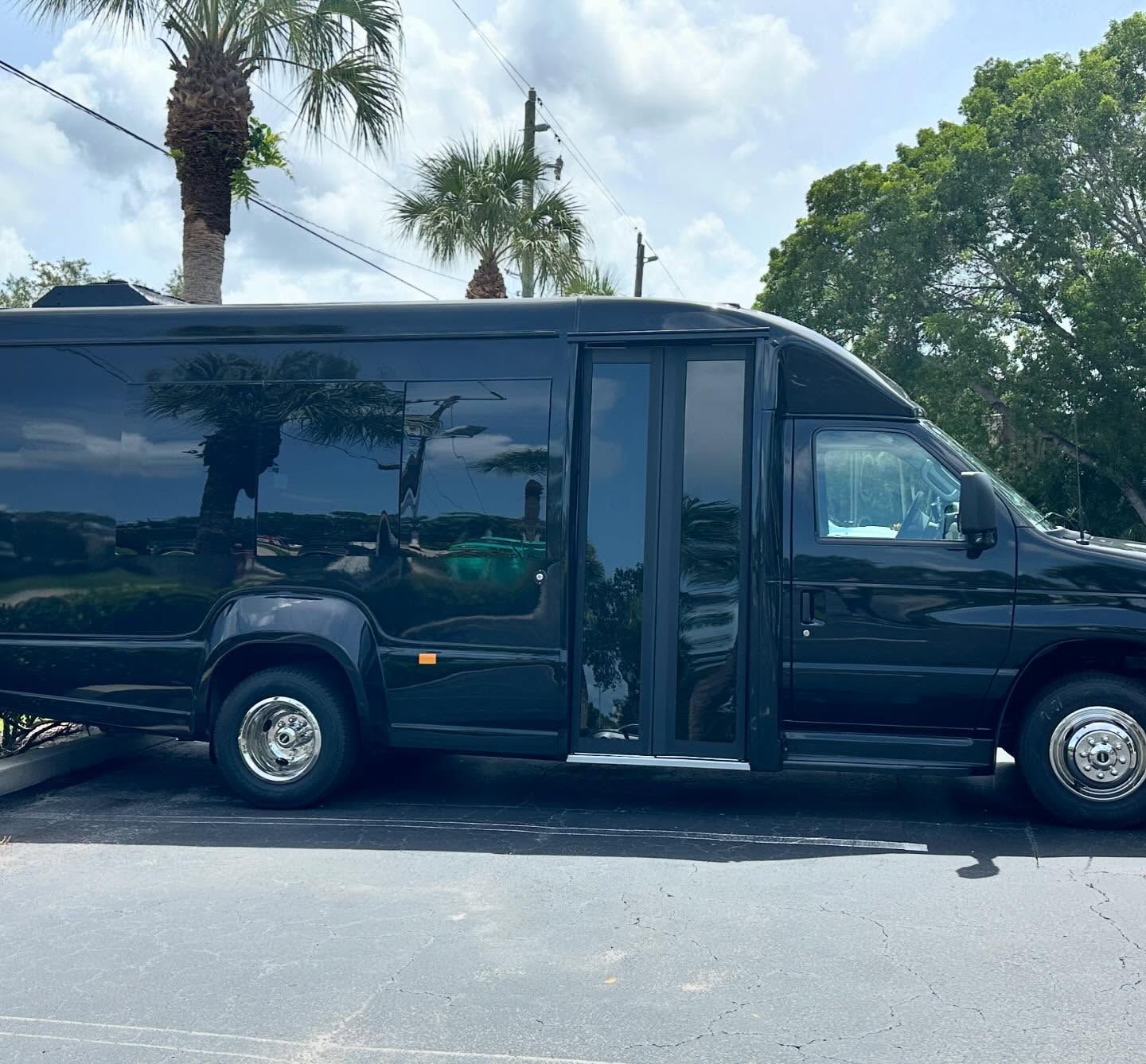 Black passenger shuttle with dark side windows and a folding entry door, shown in profile.