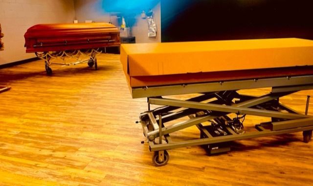 Two red and orange medical stretchers on wheels in a room with a wood floor