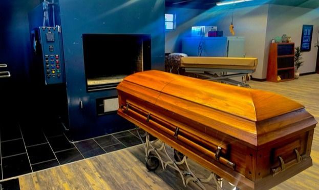 Wooden casket in a funeral home viewing room with blue walls and a polished floor