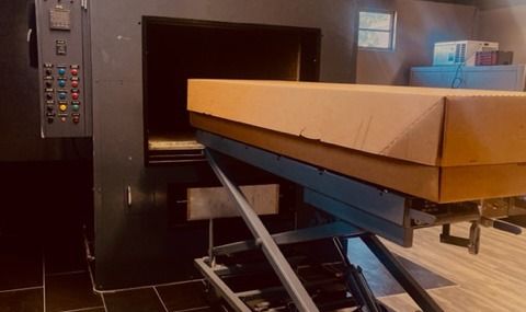 Large cardboard box on a conveyor entering an industrial machine or packaging scanner indoors