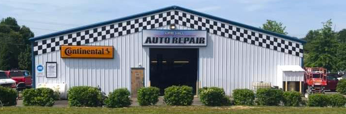 A white building with a sign that says auto repair
