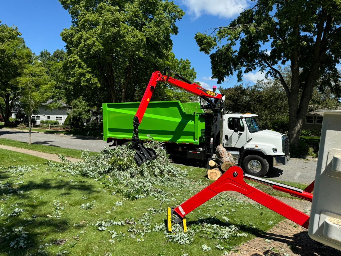 Tree maintenance service using a grapple truck for debris cleanup in Baraboo, WI.
