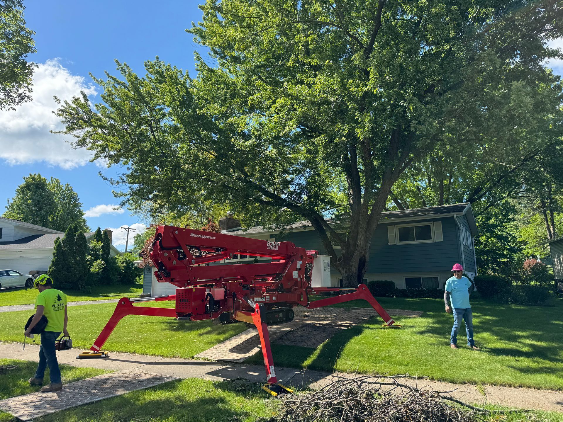 Arborists using a spider lift for tree trimming service in Baraboo, Wisconsin.