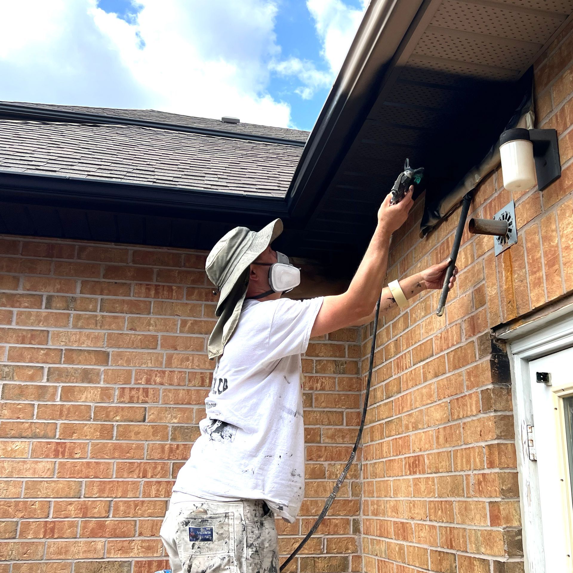 a man is painting a house with a brush .