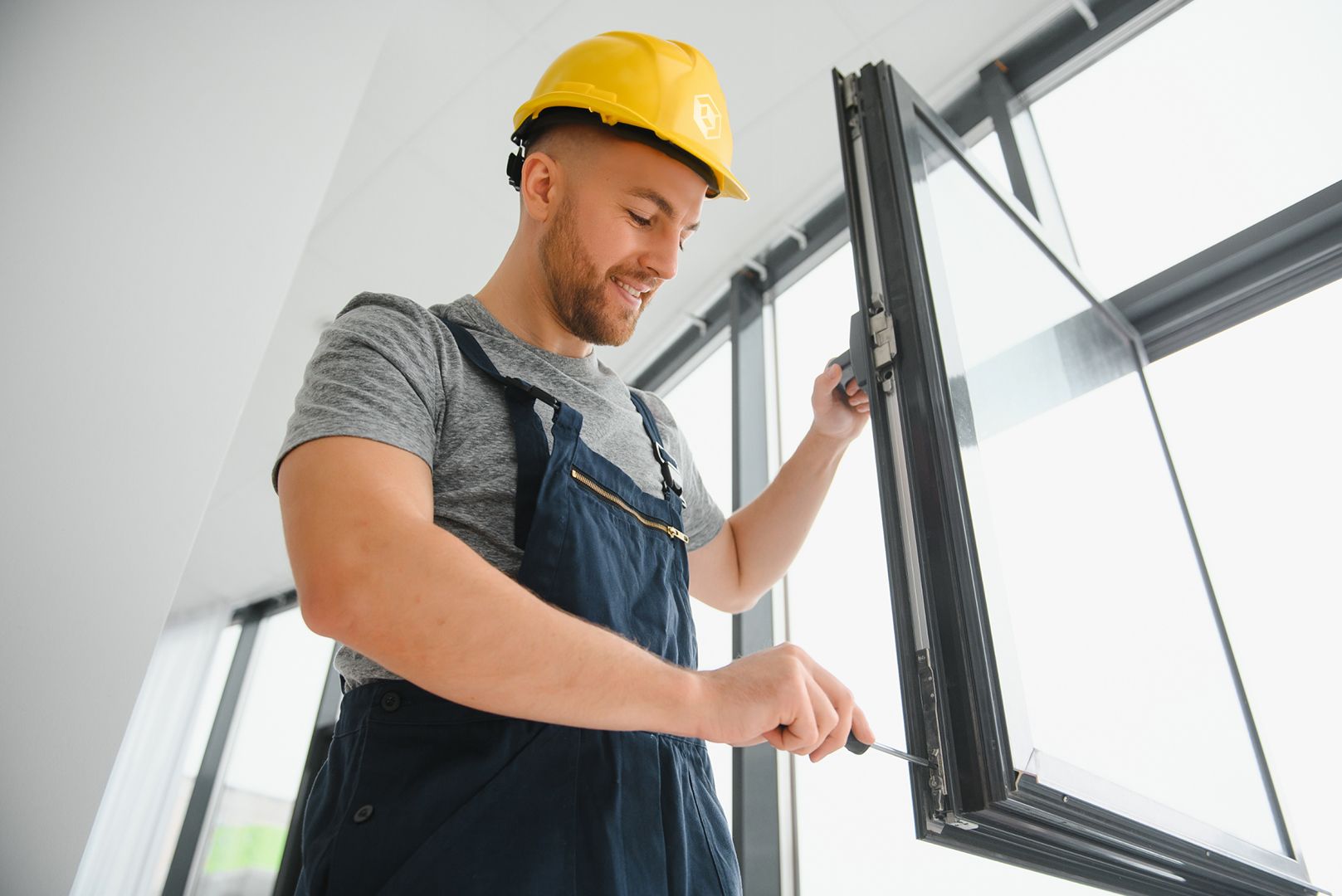 a person is painting a window frame with a brush .