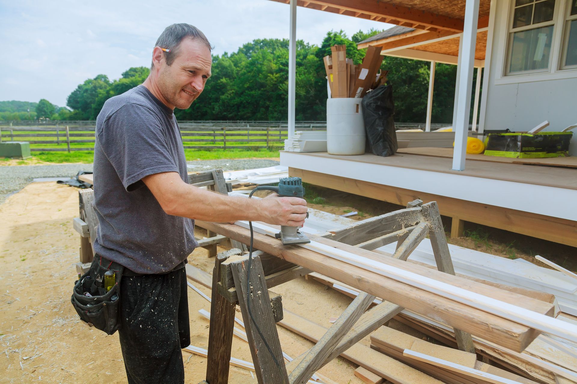 a man is using a router to cut a piece of wood .