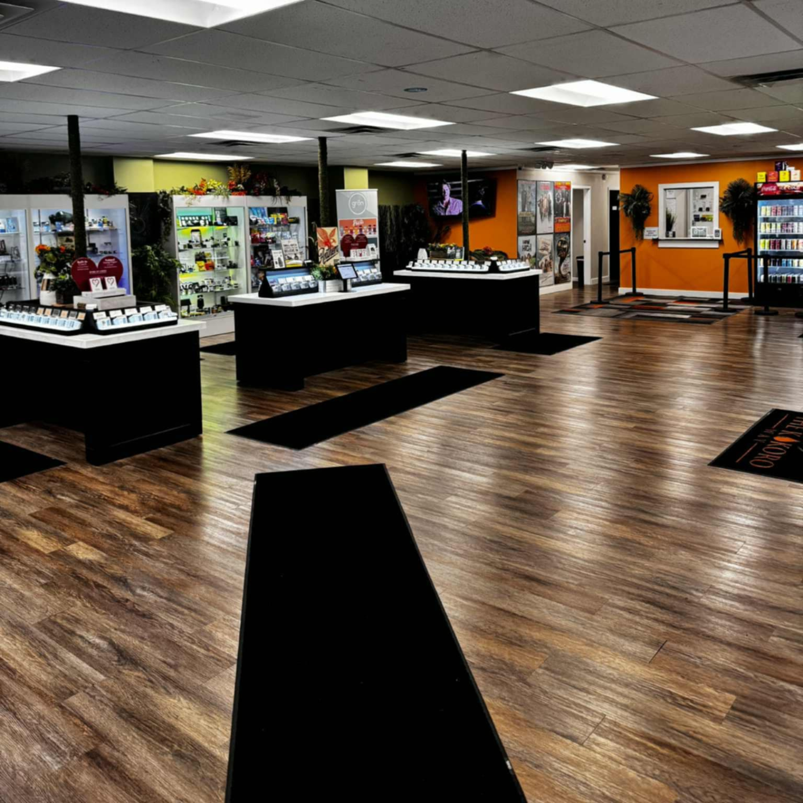 Indoor showroom with wood flooring, display counters, and bright overhead lights
