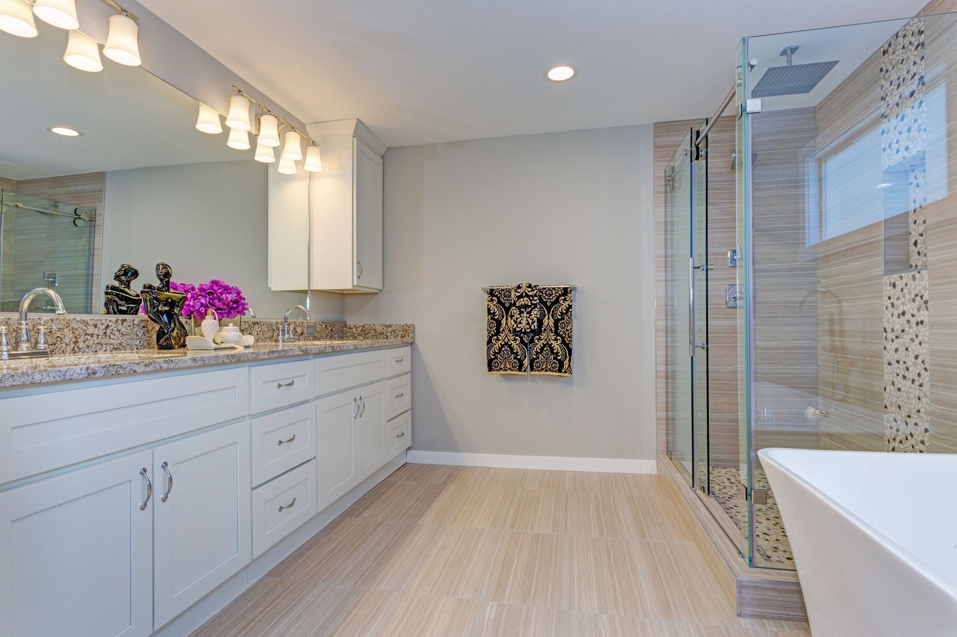 A modern bathroom featuring a walk-in shower and a freestanding bathtub, with neutral-colored tiles.